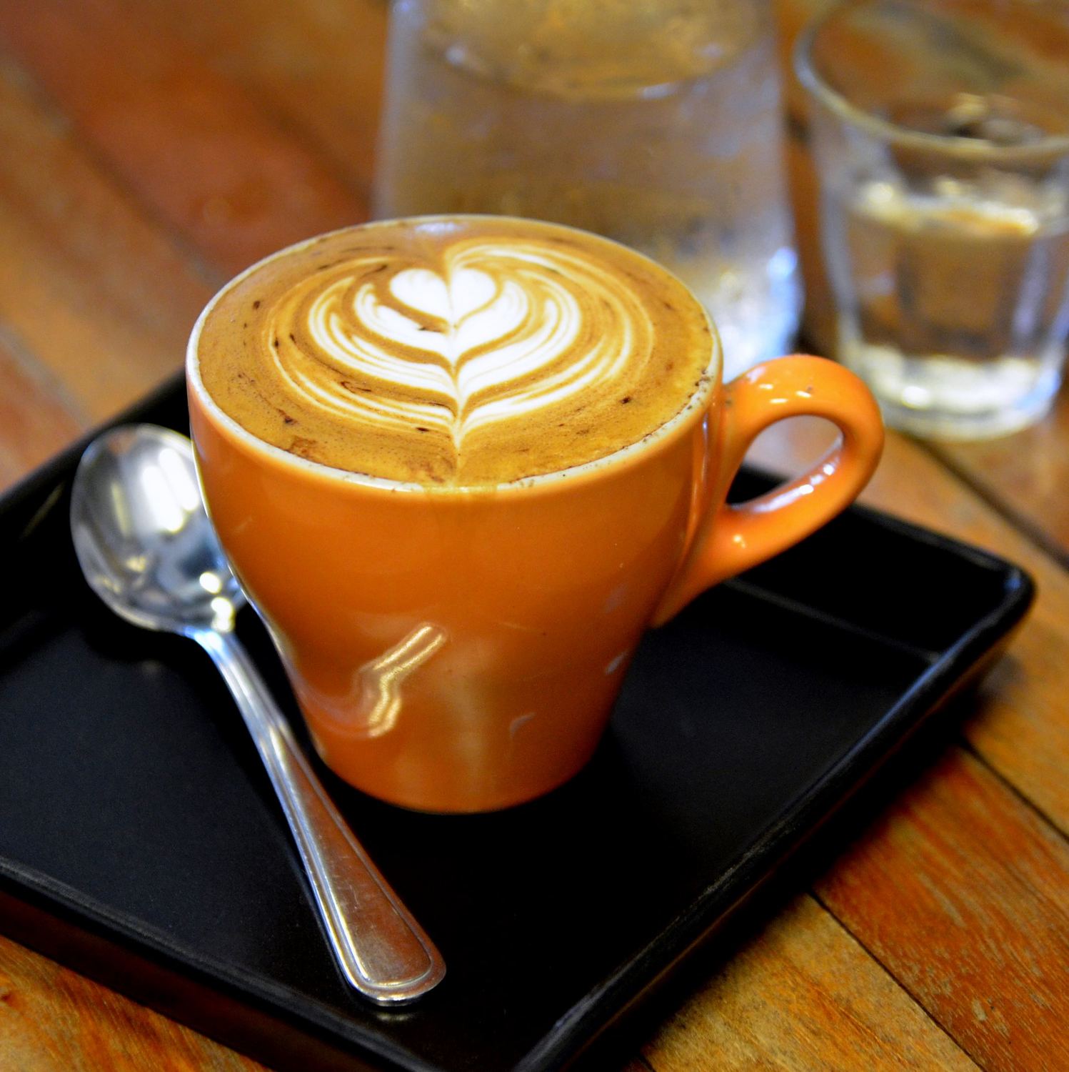 A flat white in an orange cup