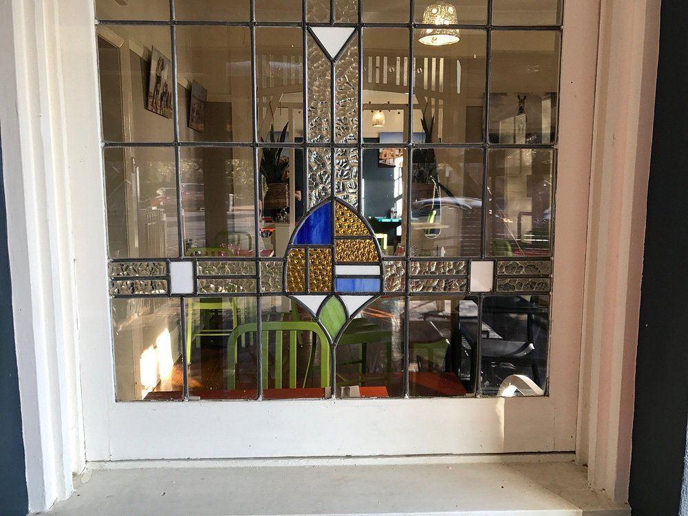 Dahab Cafe leadlight window with green chairs
